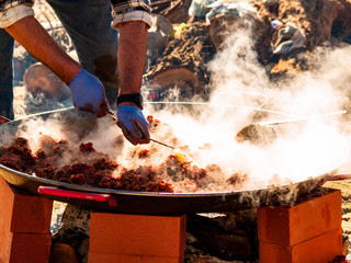 Unrecognizable person cooking traditional food called chichas on the street at a popular party in a village in Spain