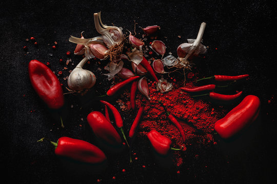 Fresh red and spicy chilli peppers on dark background. Flat lay. From above