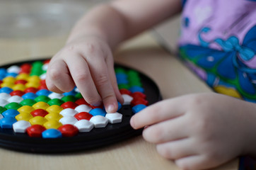 Obraz na płótnie Canvas Little child playing with mosaic
