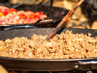 Unrecognizable person cooking traditional food called chichas on the street at a popular party in a village in Spain