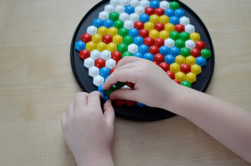 Little child playing with mosaic