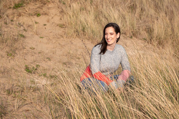 Naklejka na ściany i meble Young woman sitting among sand dunes 