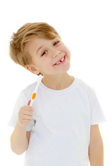 A little boy is brushing his teeth with a toothbrush.