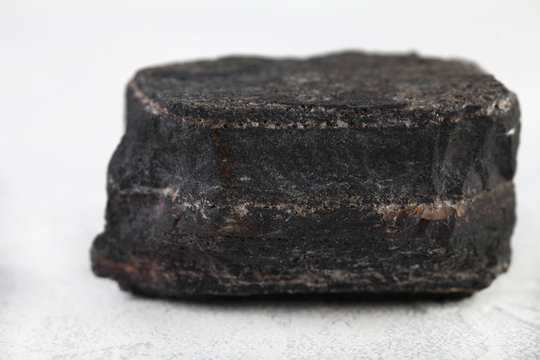 Metamorphic rock specimen - jaspillite jaspilite, ferruginous quartzite, jespillite mineral from Kursk Magnetic Anomaly, Mikhailovskoe, Russia on white cement background.