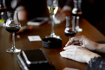 woman's hands with glasses of mulled wine and champagne