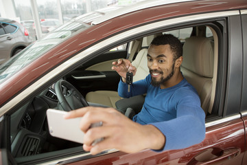 Happy male car owner showing keys to his new auto