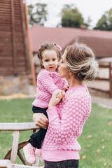 Close up portrait of pretty cute little brunette baby girl playing and hugging with mother outdoors in park. Childhood, nature, park, season, family concept