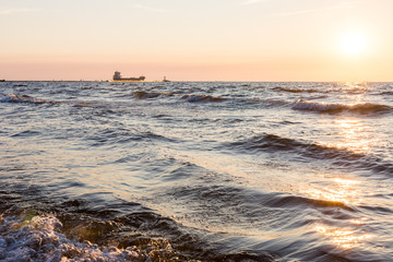 Obraz premium Sunset on coast of the sea with waves. Nature, water concept