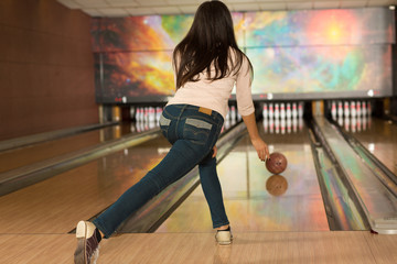 Fototapeta na wymiar Woman playing bowling alone at the club