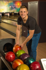 Fototapeta premium Handsome young man playing bowling alone