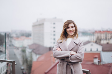 Outdoor portrait of young cheerful joyful happy woman on the roof