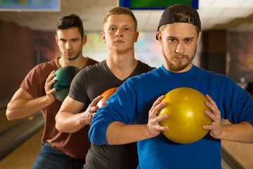 Young handsome guys friends bowling together