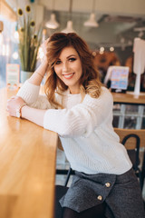 Close up portrait of young hipster modern brunette girl in cafe indoors