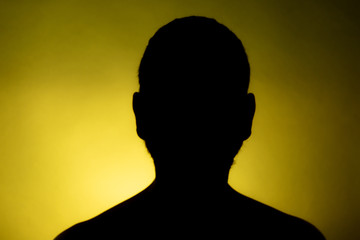 Cleanly defined frontal silhouette of a male person against a blue background with a spotlight and...