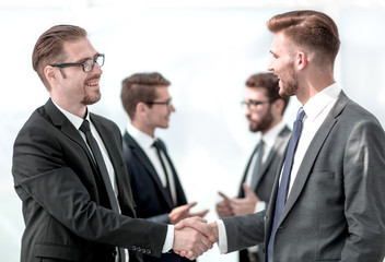 handshake of business partners on a light background
