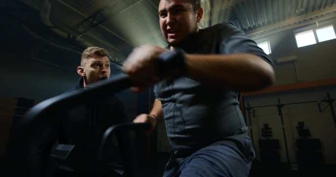 Overweight young man exercising with a machine