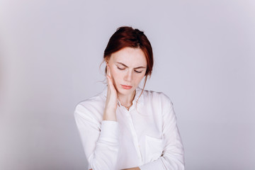 Young serious tender depressed woman on grey background