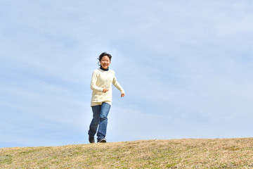 Fototapeta premium 青空で走る女の子