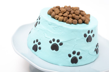 Dog food birthday cake on a cake stand isolated on white background
