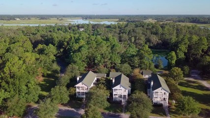 Aerial flyover of beautiful homes in wooded coastal community in South Carolina.
