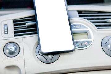 Smartphone in a car use for Navigate or GPS. Driving a car with Smartphone in holder. Mobile phone isolated white screen. Blank empty screen. copy space. Empty space for text. car interior details
