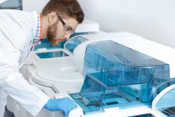 Young handsome laboratory technician working at the modern medical lab