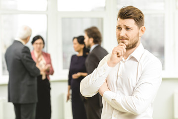 Handsome businessman looking doubtful thinking at his office