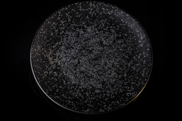 round grey textured restaurant plate on black background