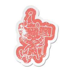 cute cartoon distressed sticker of a cat with sign wearing santa hat