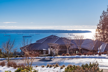 Fototapeta na wymiar Houses in suburb at Winter with ocean view in the north America. Luxury houses covered nice snow.