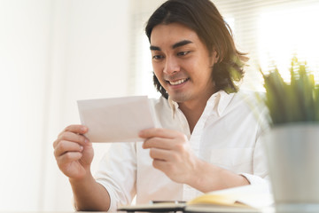 asian worker looking at bonus money from boss.