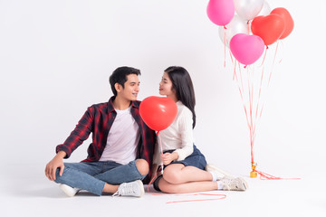Beautiful Young couple at home,enjoy spend time together in celebration Saint Valentine's day,hand hold red heart balloon,heart balloon bouquet background,happy and love motion.