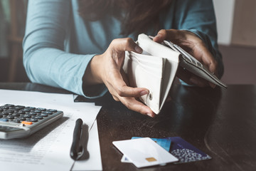Economic problem finance of young worker. Woman opening her empty wallet in the last day of month and do not have money in the purse.