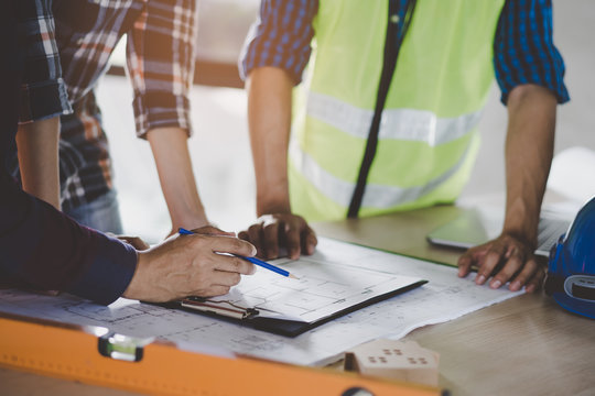 Group Of Builder Team Planning And Discussing Construction Home Drawing.