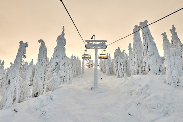 Chair lift in Poiana Brasov ski resort, Skiers and snowboarders enjoy the ski slopes in Poiana...