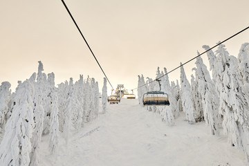 Chair lift in Poiana Brasov ski resort, Skiers and snowboarders enjoy the ski slopes in Poiana...