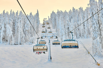 Chair lift in Poiana Brasov ski resort, Skiers and snowboarders enjoy the ski slopes in Poiana...