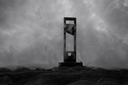 Horror view of Guillotine. Close-up of a guillotine on a dark foggy background.