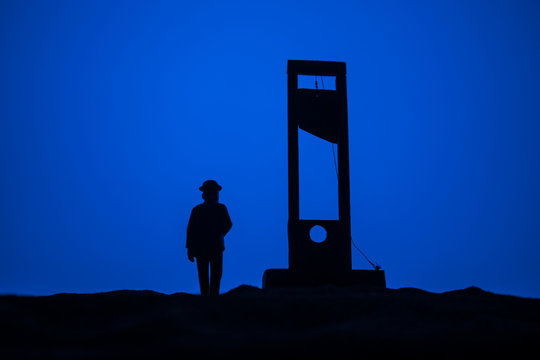 Horror view of Guillotine. Close-up of a guillotine on a dark foggy background.