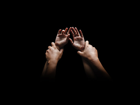 Man hands holding a woman hands for rape and sexual abuse concept isolated on black background