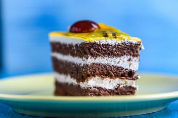 Chocolate puff cake with cherry on top photographed close-up on wooden background.