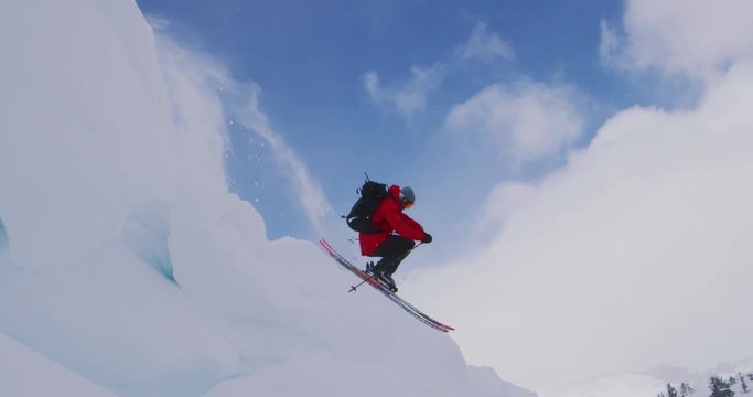 Skier jumping off of a cornice in slow motion, backcountry ski holiday