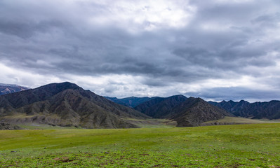 Dramatic clouds over the steppe and mountain peaks in the Altai