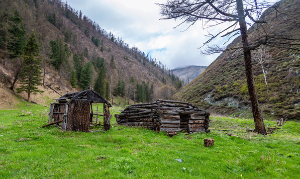 Abandoned cabin (hunters' cottage) stands in the glen between the mountains in the Altai