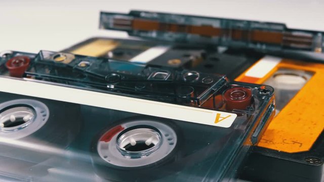 Four Audio Cassettes Rotate on White Background