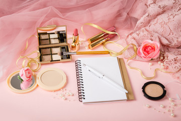 Obraz na płótnie Canvas Woman's cosmetics and diary. Nail polish, powder on romantic pink tulle background. Women's secrets, list of wishes. Pink and golden colors. Decorative cosmetics. Planning of shopping. Beauty secrets