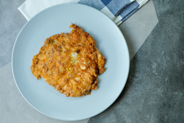Crispy Thai omelet pork in blue ceramic plate