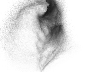 Black powder explosion against white background. Charcoal dust particles exhale in the air.