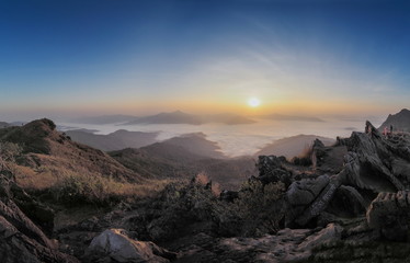 sunrise at Doi Pha Tang, mountain view misty morning on top hill around with ocean of mist above Mekong river with colorful red and yellow light in the sky background, Phatang, Chiang Rai, Thailand.