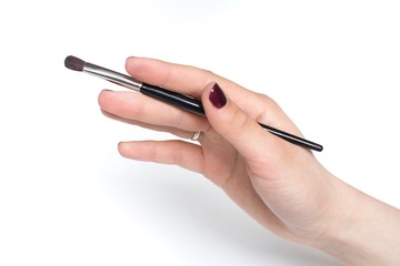 young woman holding black makeup brush  on white background